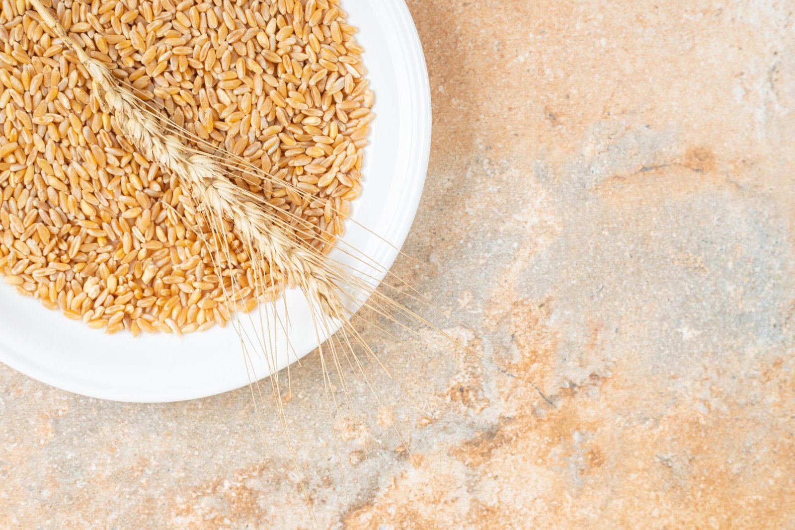 Grain And Wheat Ear On A Plate , On The Marble Background